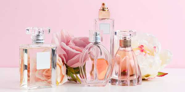 A collection of perfume bottles displayed next to flowers.
